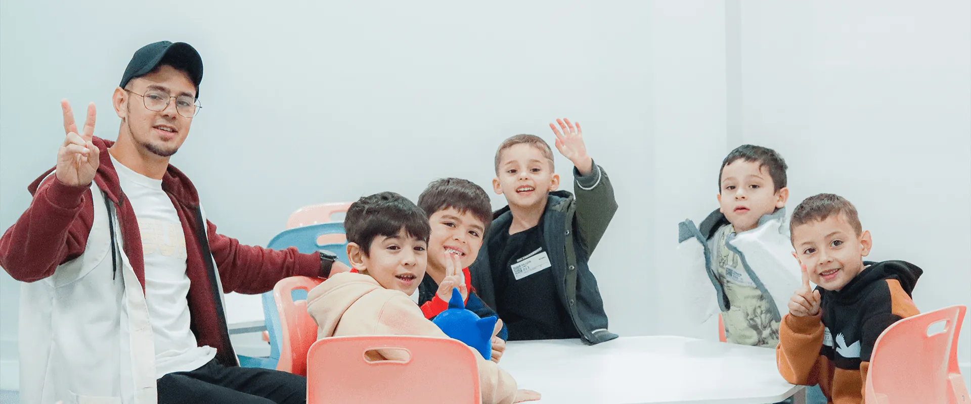 Voluntário do Alcance Kids com crianças em sala